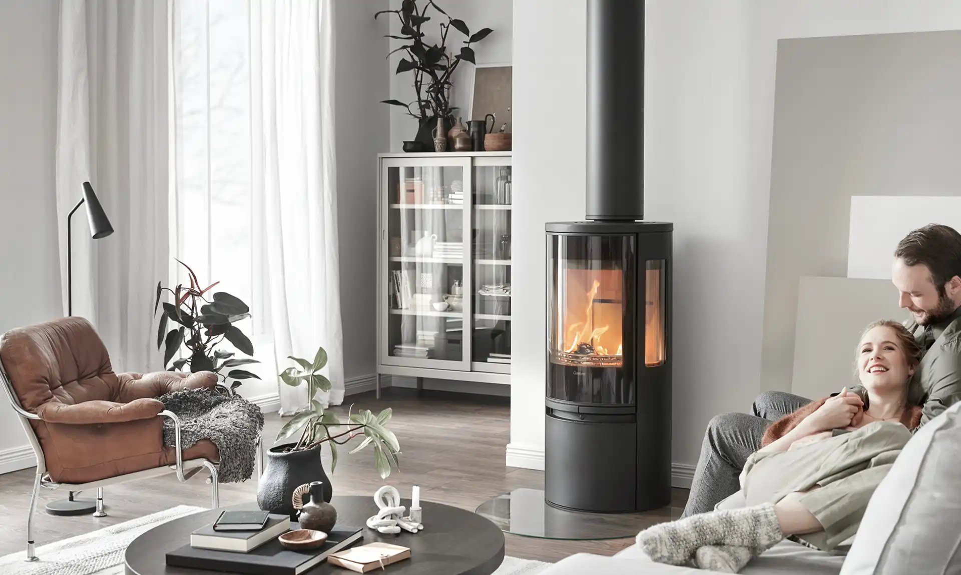 Couple d'adultes devant un poêle à bois en feu